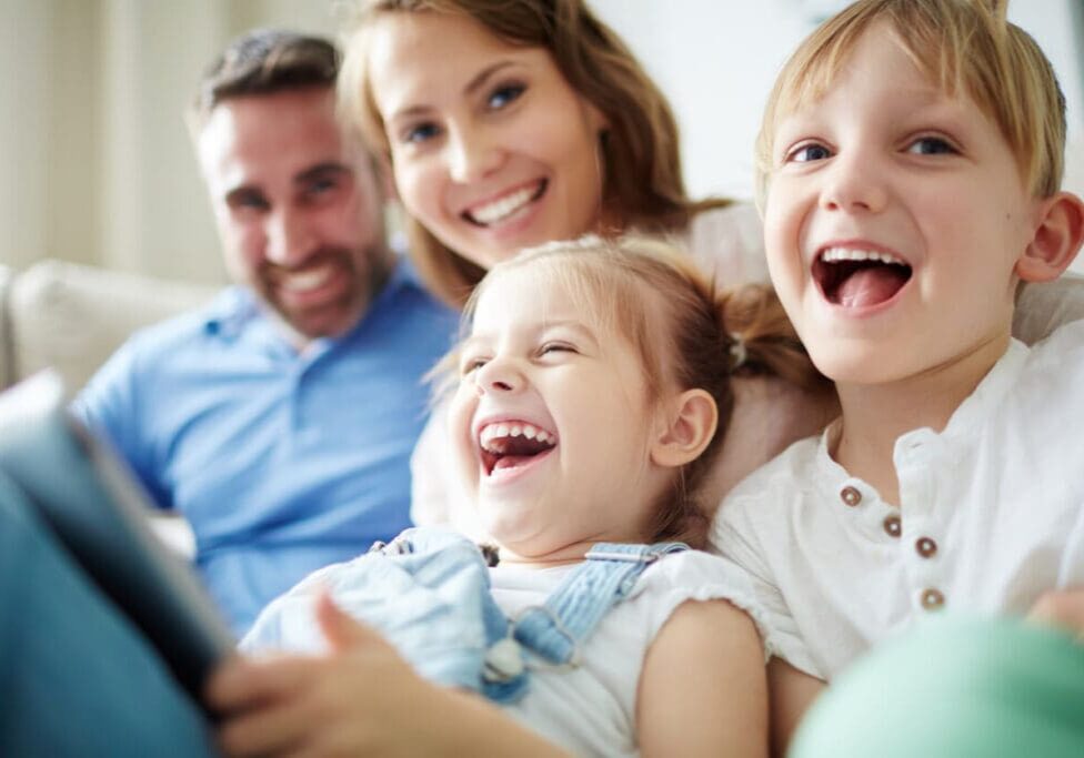 happy-family-portrait Children sitting together with parents and laughing.